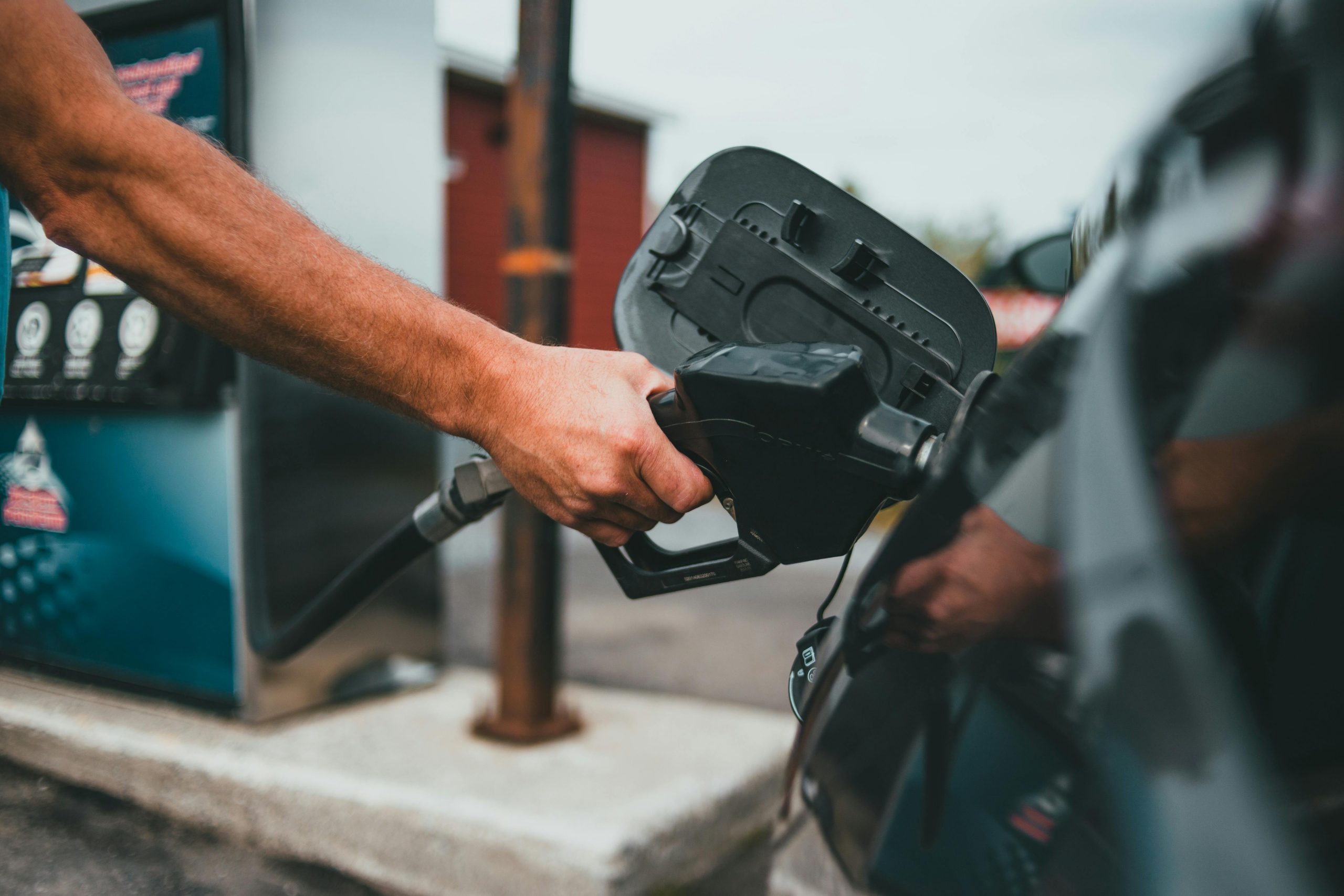 close-up of hand fueling a black car